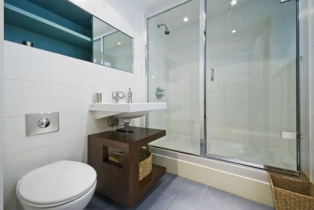 Completed shower installation with coordinated fixtures, shelving, and enclosure