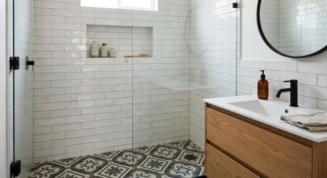 Patterned bathroom floor tile beside a tiled shower wall